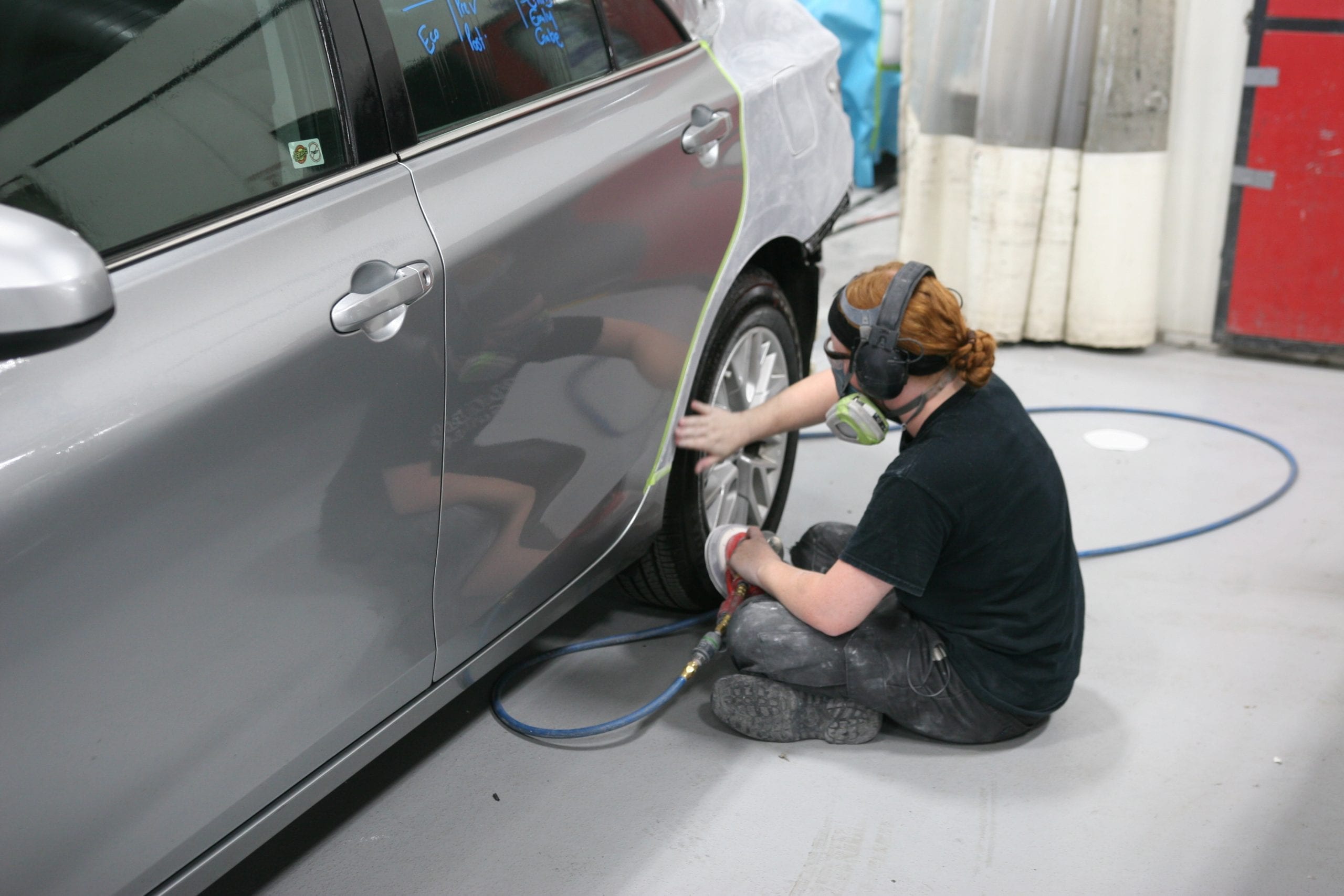 Collision technician working on car