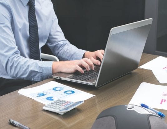 man typing on laptop
