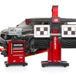 Un système de calibration Ultimate ADAS de Hunter Engineering Company positionné devant un véhicule pour l'alignement des roues. L'équipement comprend une structure rouge avec des cibles de calibration et une console de commande informatisée.