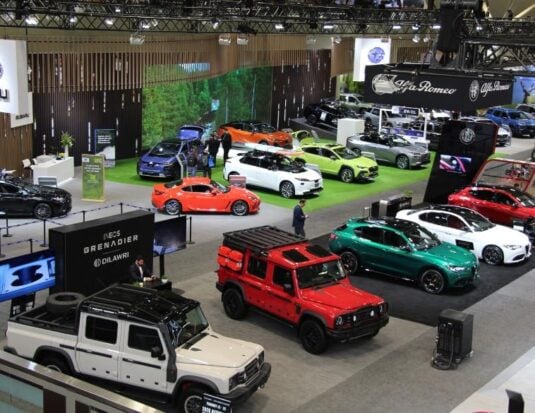 A high-angle view of the 2026 Canadian International AutoShow floor, showcasing a wide variety of vehicles from brands such as INEOS Grenadier, Alfa Romeo, and Subaru on display for attendees.