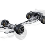 A detailed technical illustration of a vehicle’s complete undercarriage, drivetrain, and suspension system against a white background. The rendering showcases complex components like the engine, CV axles, hub assemblies, and exhaust system, reflecting GSP North America’s focus on engineering high-quality undercar products built for reliability in extreme conditions.