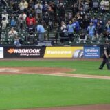 Hankook Tire branding on a digital baseline scoreboard at a Major League Baseball stadium during a game with fans in the stands.