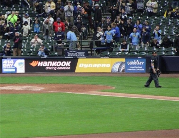 Hankook Tire branding on a digital baseline scoreboard at a Major League Baseball stadium during a game with fans in the stands.