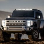 Vue de trois-quarts avant du Concept Hyundai Boulder , un VUS robuste monté sur un châssis sur cadre. Le véhicule arbore un design vertical « Art of Steel » avec des pneus de boue de 37 pouces , des phares à DEL verticaux et une barre lumineuse sur le toit, le tout positionné sur un terrain rocheux.