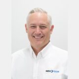 Professional headshot of Mike Lofgren, Mevotech’s Vice President of Retail Sales, smiling and wearing a white Mevotech branded shirt.