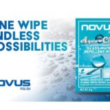 Promotional graphic for NOVUS® Polish AquaClear Glass Water Repellent Wipe featuring a blue product sachet and the headline "ONE WIPE ENDLESS POSSIBILITIES" against a background of water droplets. Inset images show the product's use on car windshields and glass showers.