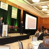 A speaker stands on a stage with a podium and large screen during a presentation at the OARA Convention 2026, where over 430 attendees gathered for the association's best-attended event on record.