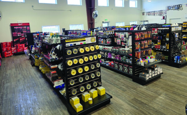 A well-organized retail interior of an Auto Electric Service Ltd. location, featuring rows of shelves stocked with automotive parts and industrial tools.