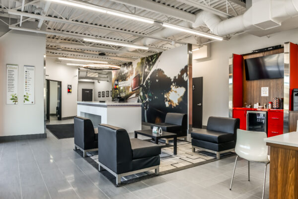 La zone de réception accueillante et moderne de Fix Auto Edmonton West, comprenant des sièges noirs confortables et une image de marque professionnelle.