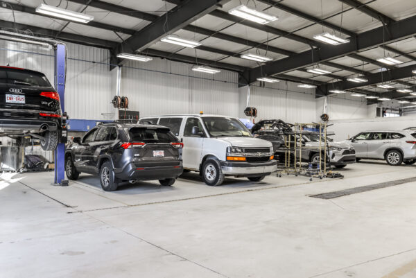 A technician working on a vehicle's structural components inside the Fix Auto Edmonton West facility, demonstrating the shop's capability for complex collision repairs.