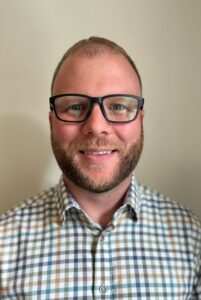 Headshot of Aaron Hebb , Services Consultant for Eastern Canada at AkzoNobel Coatings, wearing glasses and a plaid shirt against a neutral background.
