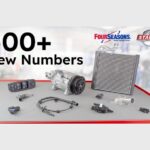 Image promotionnelle de Standard Motor Products pour le lancement de son T1 2026, avec le texte « 500+ Nouveaux Numéros » et les logos de Four Seasons et Standard. L'image présente diverses pièces automobiles, dont un compresseur de climatisation, un radiateur, un commutateur de lève-vitre électrique et un câble de capteur ABS. Les pièces sont disposées sur un établi d'atelier.