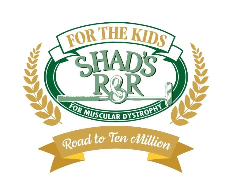 A charity logo with gold and green elements. An upper gold banner reads "FOR THE KIDS". A large green oval frames "SHAD'S R&R" with a crossed golf club and the text "FOR MUSCULAR DYSTROPHY". Gold wheat stalks frame the sides, and a lower gold banner reads "Road to Ten Million".