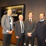 (L-R) Huw Williams, David Adams, Brian Kingston, and Flavio Volpe standing together in front of a screen displaying the AutoShow logo during a 2026 press conference.