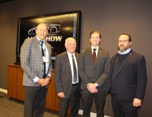(L-R) Huw Williams, David Adams, Brian Kingston, and Flavio Volpe standing together in front of a screen displaying the AutoShow logo during a 2026 press conference.