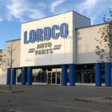 The exterior of a Lordco Auto Parts retail store with a large white and blue sign against a clear sky.