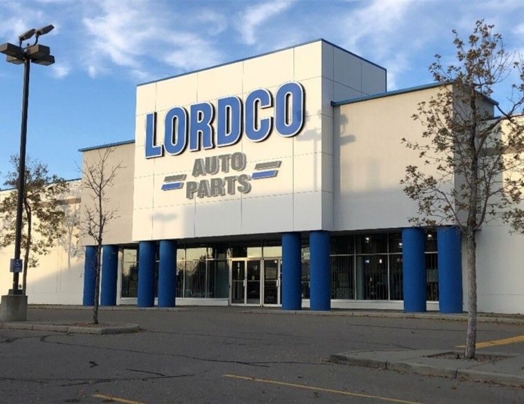 The exterior of a Lordco Auto Parts retail store with a large white and blue sign against a clear sky.