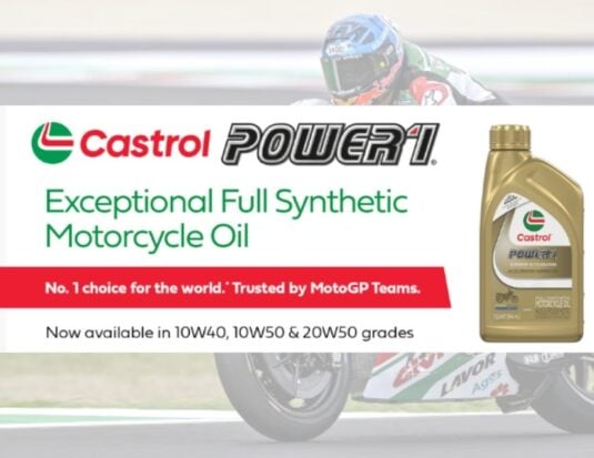 Promotional banner for Castrol Power1 full synthetic motorcycle oil featuring a 10W-50 bottle and a MotoGP racer. The text identifies it as a top choice for world teams and lists available grades: 10W40, 10W50, and 20W50.
