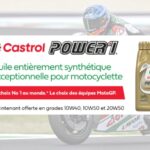 Bannière promotionnelle pour l'huile Castrol Power1, une huile entièrement synthétique pour motocyclette. L'image présente un bidon doré de 10W-50 et mentionne qu'il s'agit du choix des équipes de MotoGP. Le texte précise que l'huile est maintenant offerte en grades 10W40, 10W50 et 20W50. En arrière-plan, on aperçoit un pilote de course sur une moto.